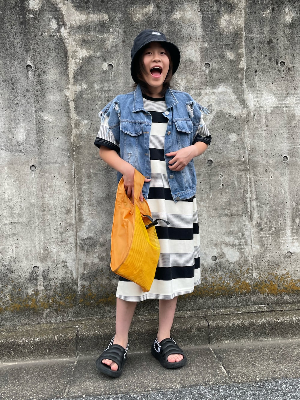 ブルー系のデニムジャケット、その他のワンピース、イエロー系のエコバッグ/サブバッグを着用したキッズの夏コーディネートの4枚目の写真