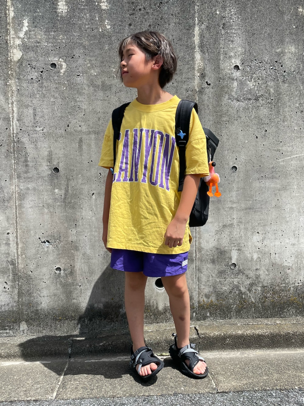 イエロー系のTシャツ/カットソー、パープル系のその他パンツ、ブラック系のバックパック/リュックを着用したキッズの夏コーディネートの5枚目の写真