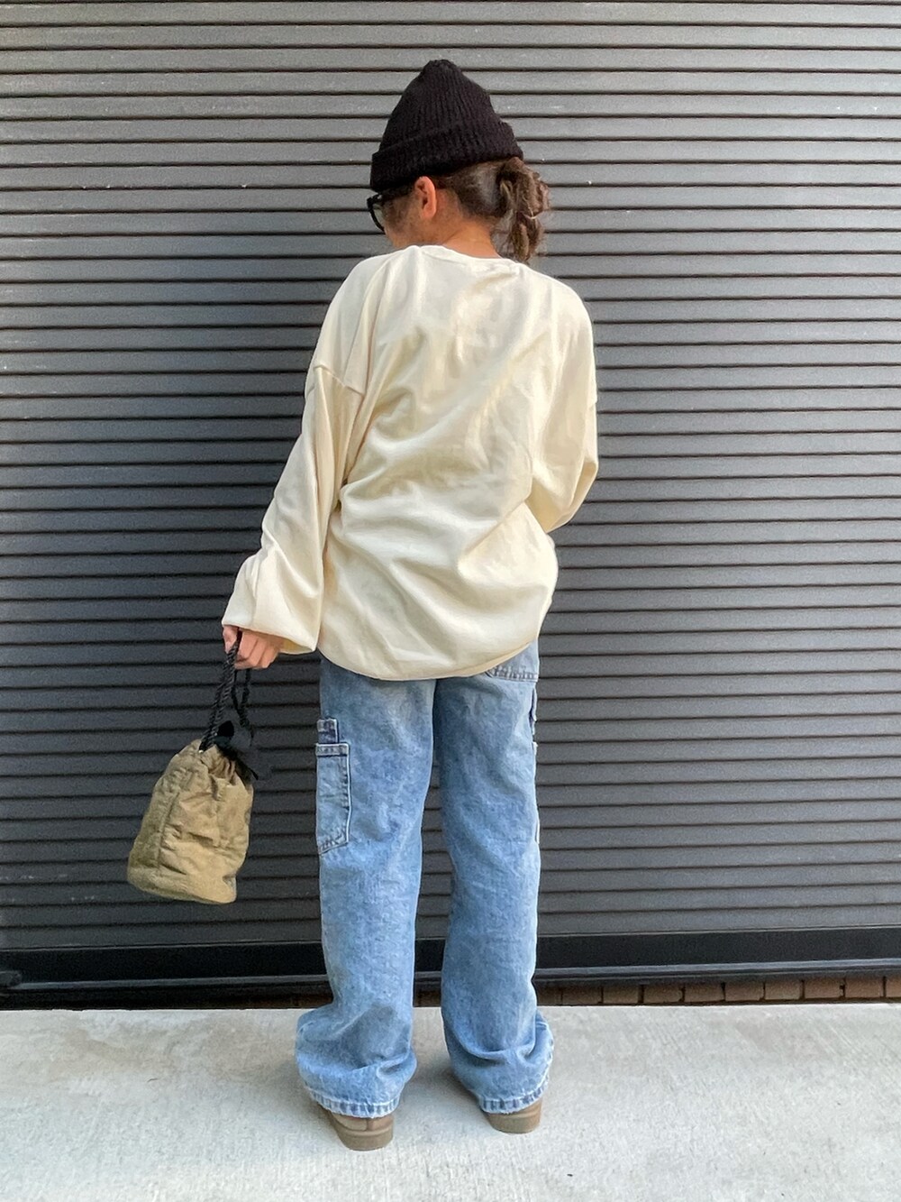 ホワイト系のスウェット、ブルー系のデニムパンツ、グリーン系のショルダーバッグを着用したキッズの秋コーディネートの2枚目の写真