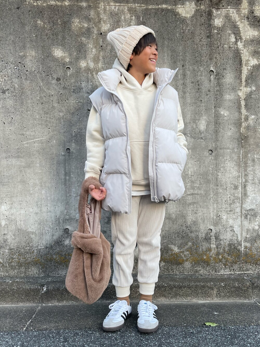 ホワイト系のダウンベスト、ホワイト系のアンサンブル、ホワイト系のパンツを着用したキッズの冬コーディネートの4枚目の写真
