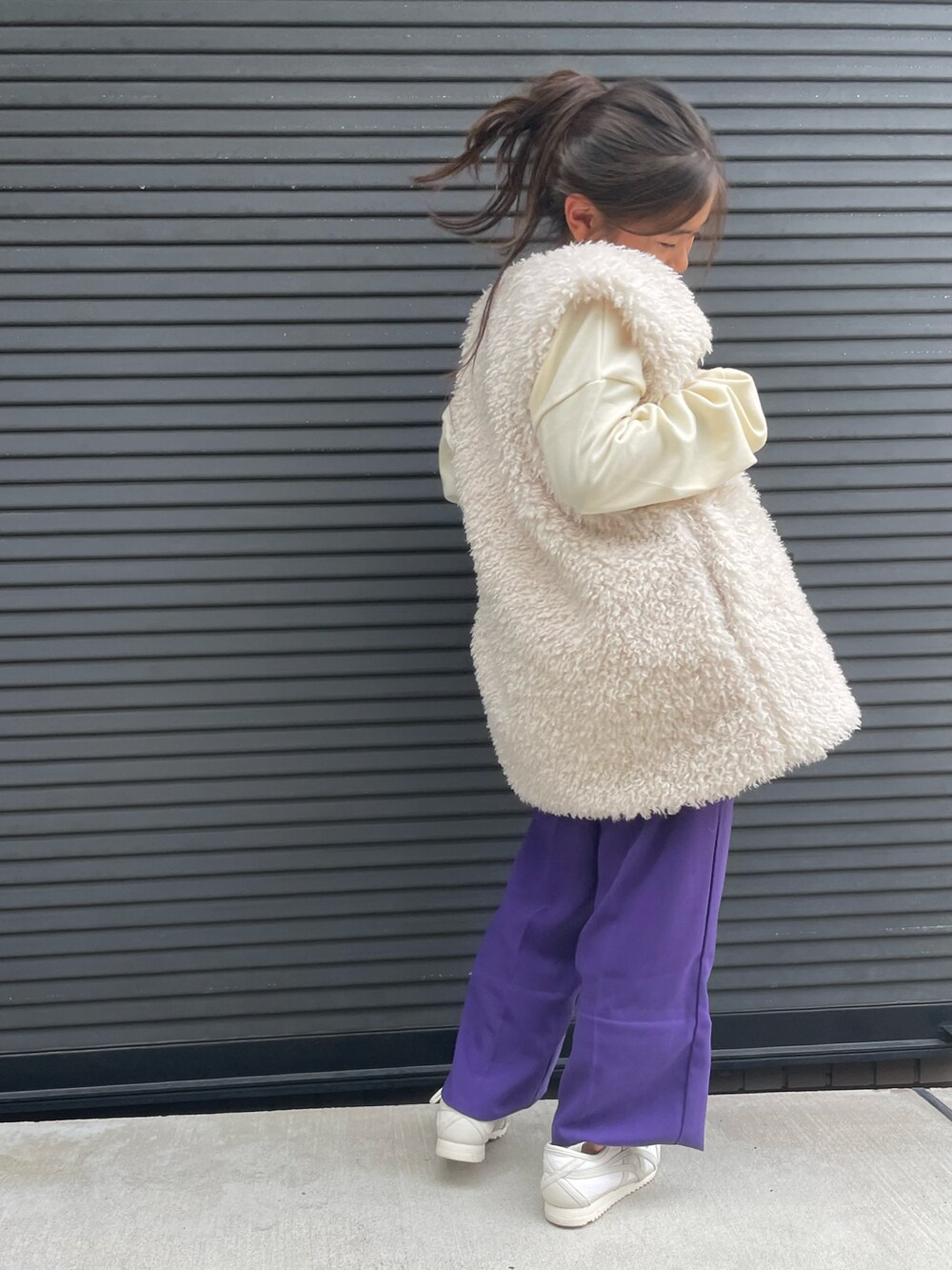 ホワイト系のベスト、ホワイト系のスウェット、パープル系のその他パンツを着用したキッズの秋コーディネートの4枚目の写真