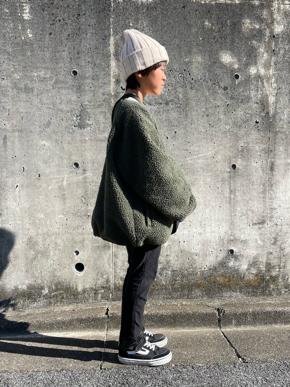 グリーン系のその他アウター、ホワイト系のスウェット、ブラック系のその他パンツを着用したキッズの冬コーディネートの2枚目の写真