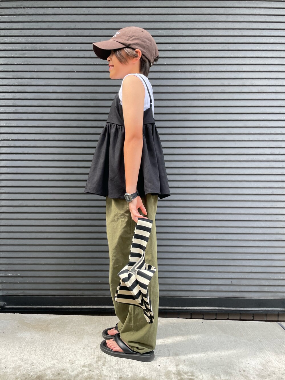 ブラック系のキャミソール、グリーン系のカーゴパンツ、ホワイト系のタンクトップを着用したキッズの夏コーディネートの2枚目の写真