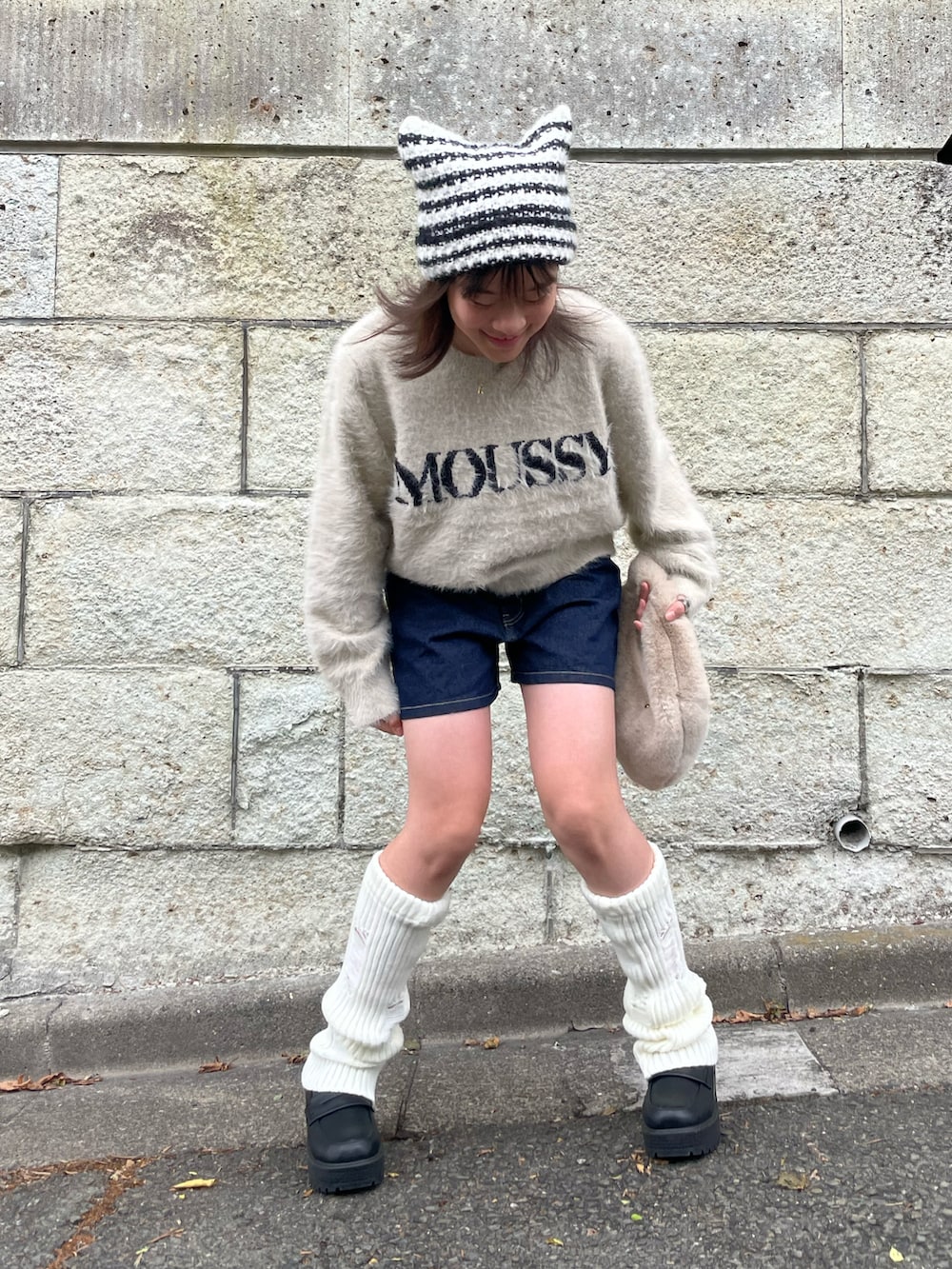 ホワイト系のニット/セーター、ブルー系のデニムパンツ、ベージュ系のハンドバッグを着用したキッズの秋コーディネートの4枚目の写真