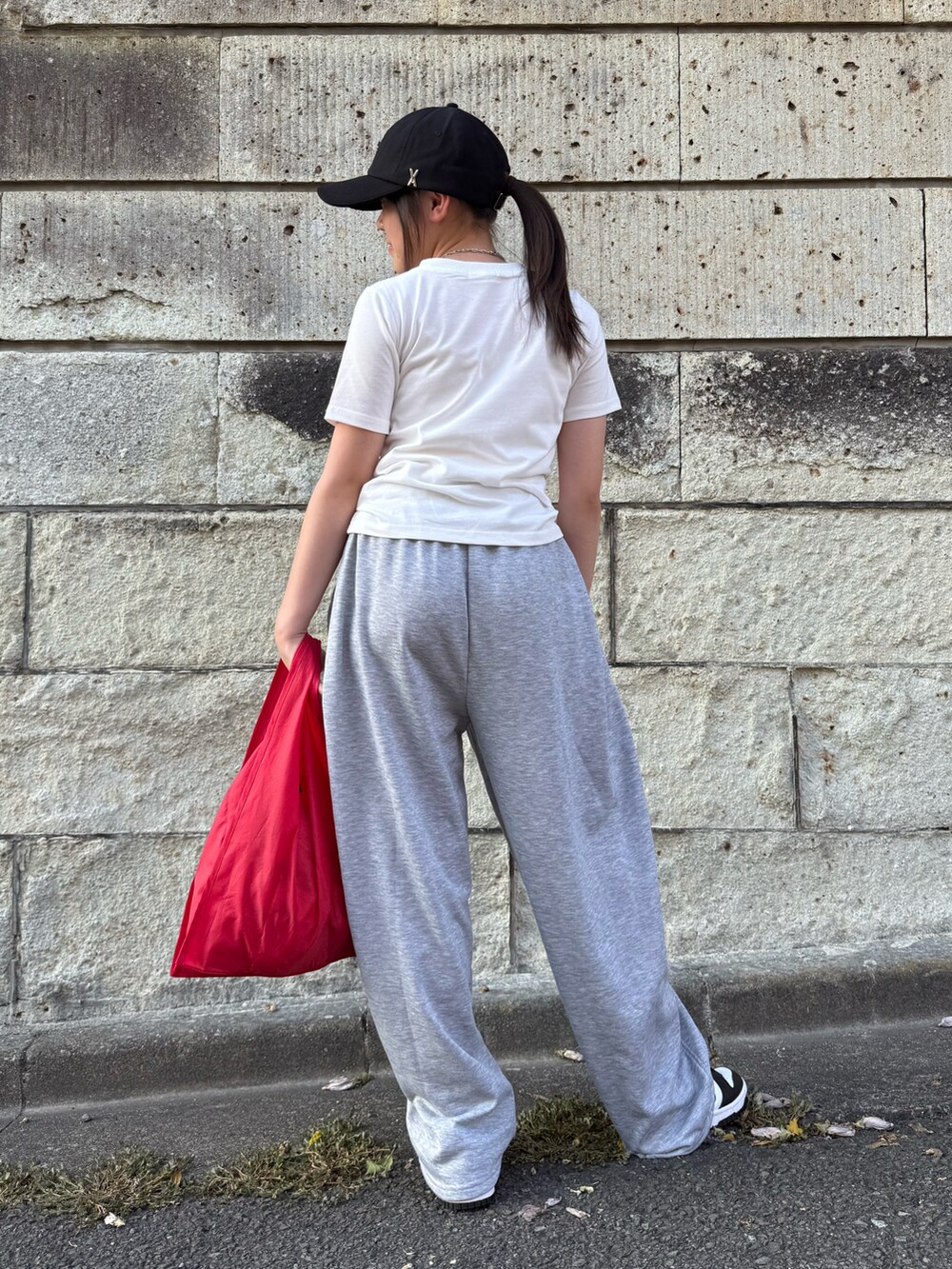 ホワイト系のスニーカー、ホワイト系のTシャツ/カットソー、レッド系のエコバッグ/サブバッグを着用したキッズの夏コーディネートの4枚目の写真