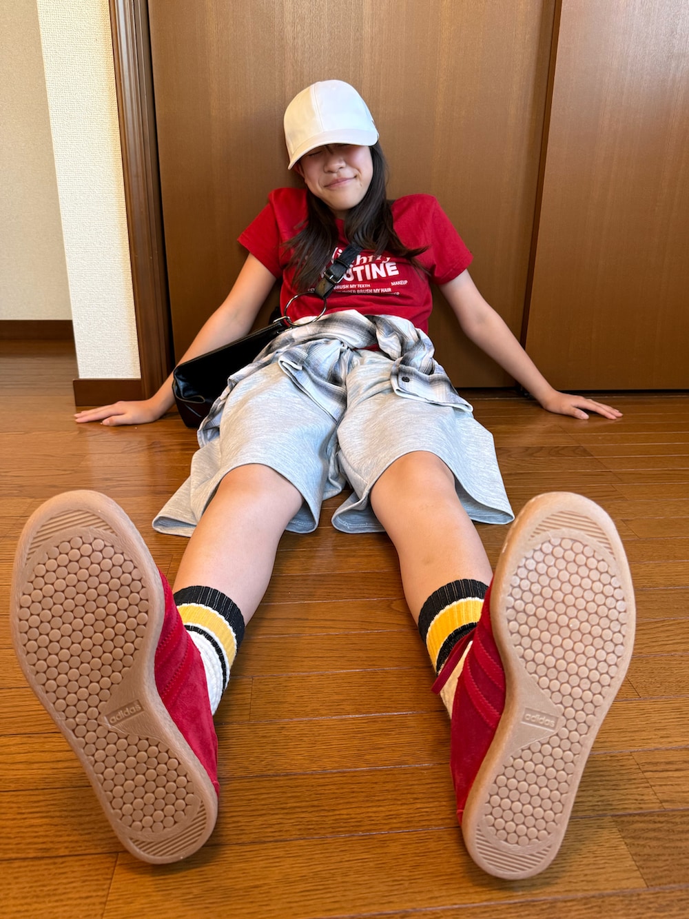 グレー系のスウェットパンツ、レッド系のTシャツ/カットソー、ブラック系のトートバッグを着用したレディースの秋コーディネートの3枚目の写真