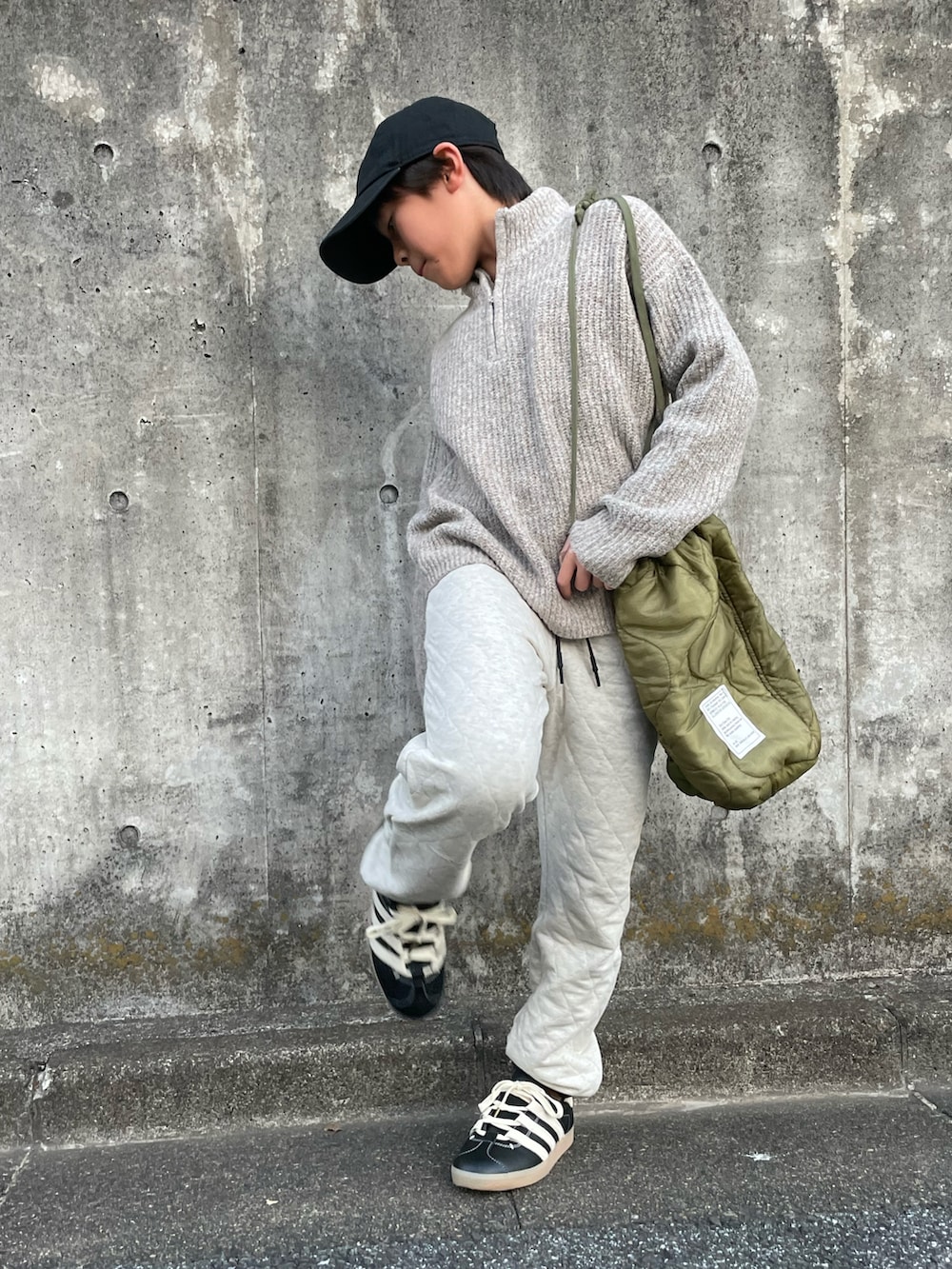 ベージュ系のニット/セーター、ベージュ系のスウェットパンツ、グリーン系のショルダーバッグを着用したキッズの冬コーディネートの4枚目の写真