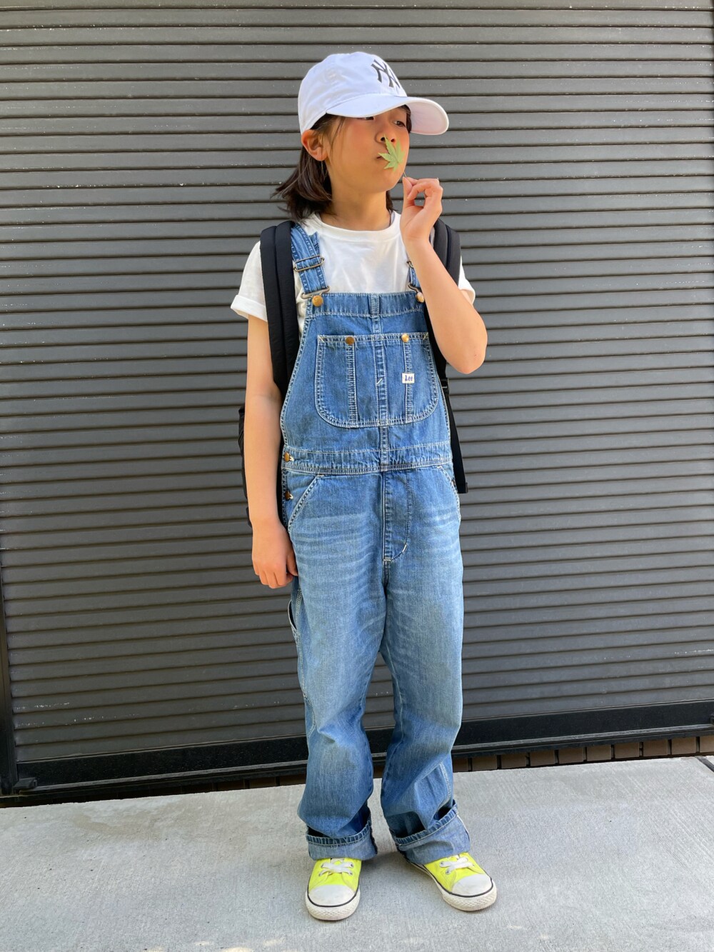 ブルー系のサロペット/オーバーオール、ブラック系のバックパック/リュック、ホワイト系のTシャツ/カットソーを着用したキッズの春コーディネートの5枚目の写真