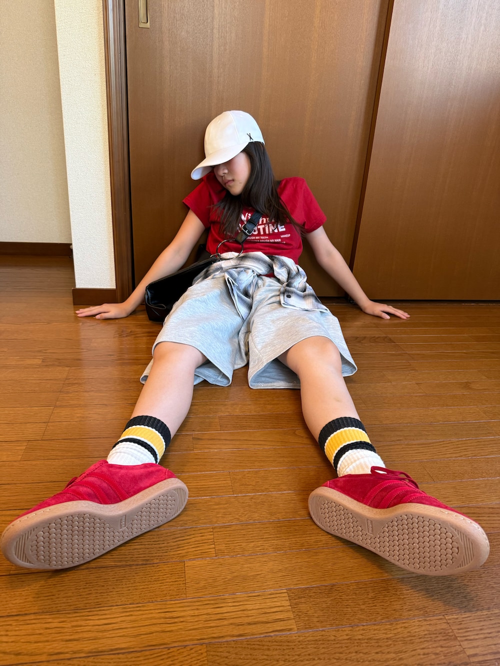 グレー系のスウェットパンツ、レッド系のTシャツ/カットソー、ブラック系のトートバッグを着用したレディースの秋コーディネートの2枚目の写真