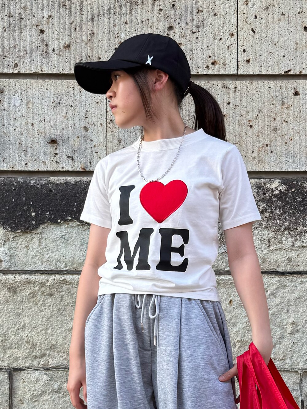 ホワイト系のスニーカー、ホワイト系のTシャツ/カットソー、レッド系のエコバッグ/サブバッグを着用したキッズの夏コーディネートの5枚目の写真