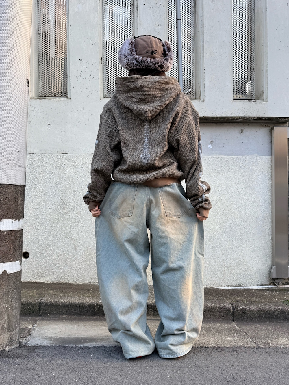 ブラック系のスニーカー、ブルー系のデニムパンツ、その他のパーカーを着用したレディースの冬コーディネートの4枚目の写真