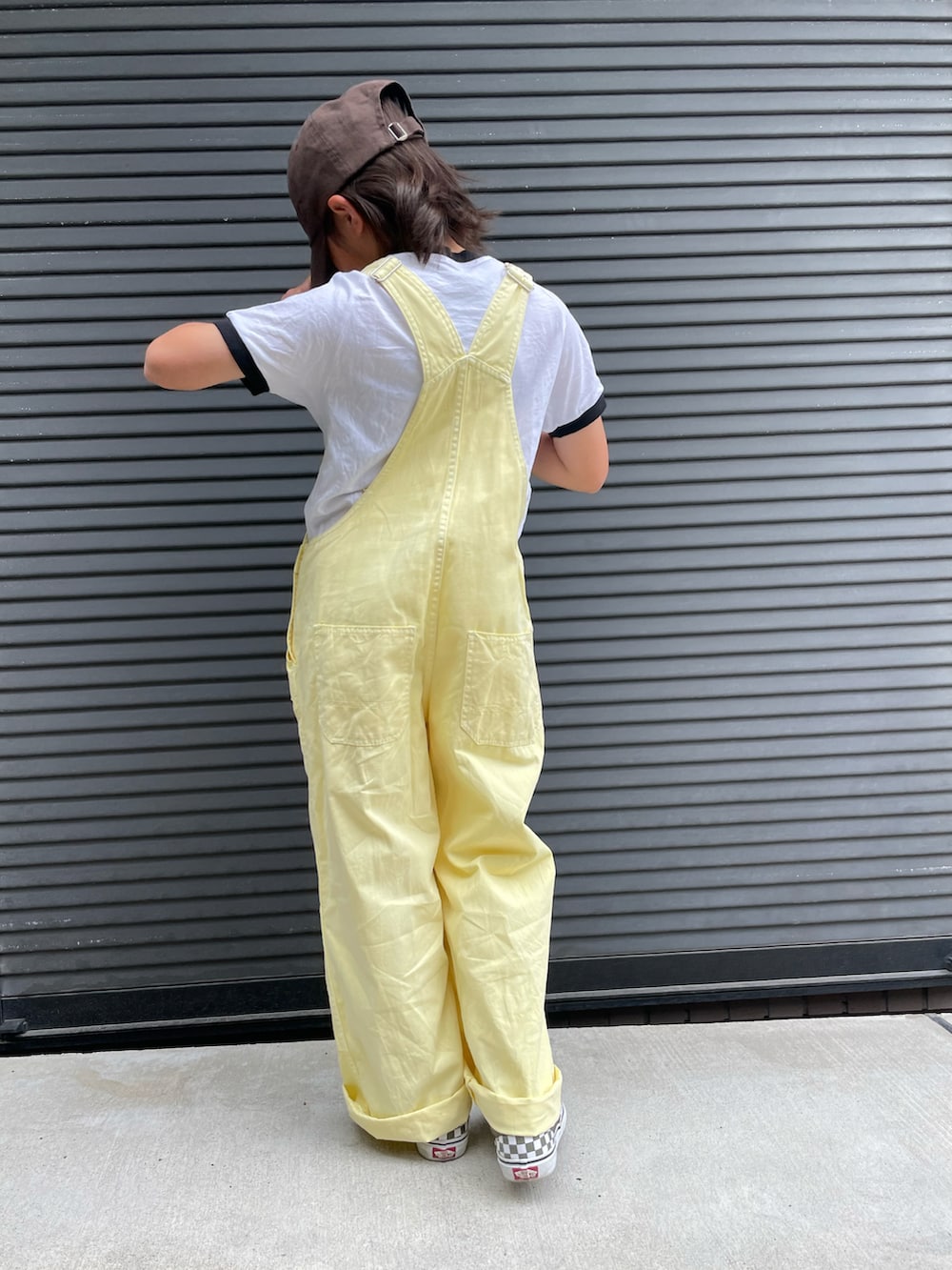 イエロー系のサロペット/オーバーオール、ホワイト系のTシャツ/カットソー、グリーン系のスニーカーを着用したキッズの春コーディネートの3枚目の写真