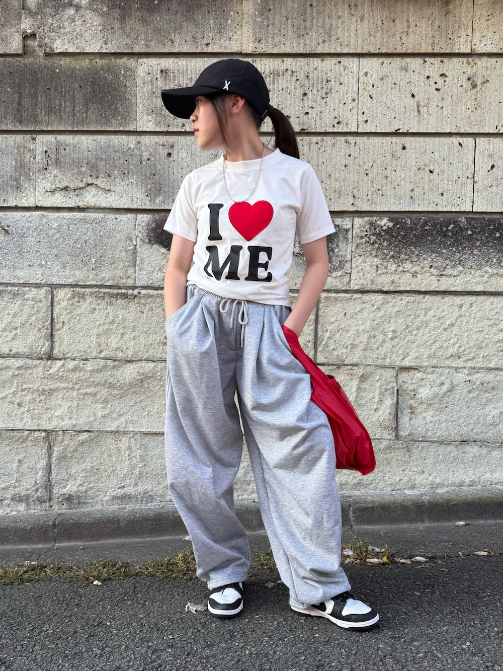 ホワイト系のスニーカー、ホワイト系のTシャツ/カットソー、レッド系のエコバッグ/サブバッグを着用したキッズの夏コーディネートの2枚目の写真