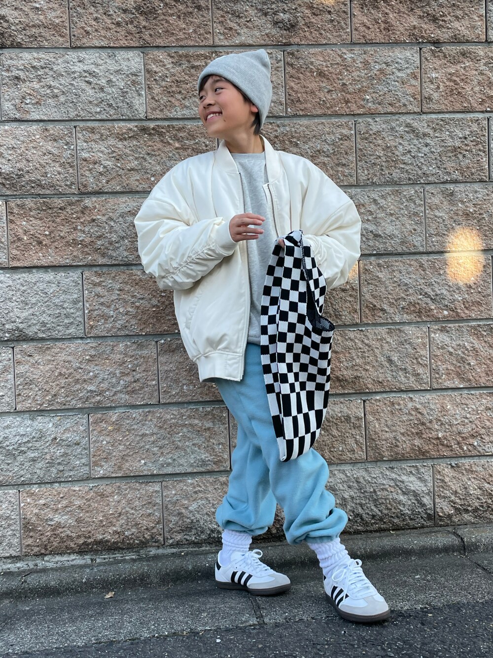 ホワイト系のミリタリージャケット、グレー系のスウェット、ブルー系のその他パンツを着用したキッズの秋コーディネートの2枚目の写真