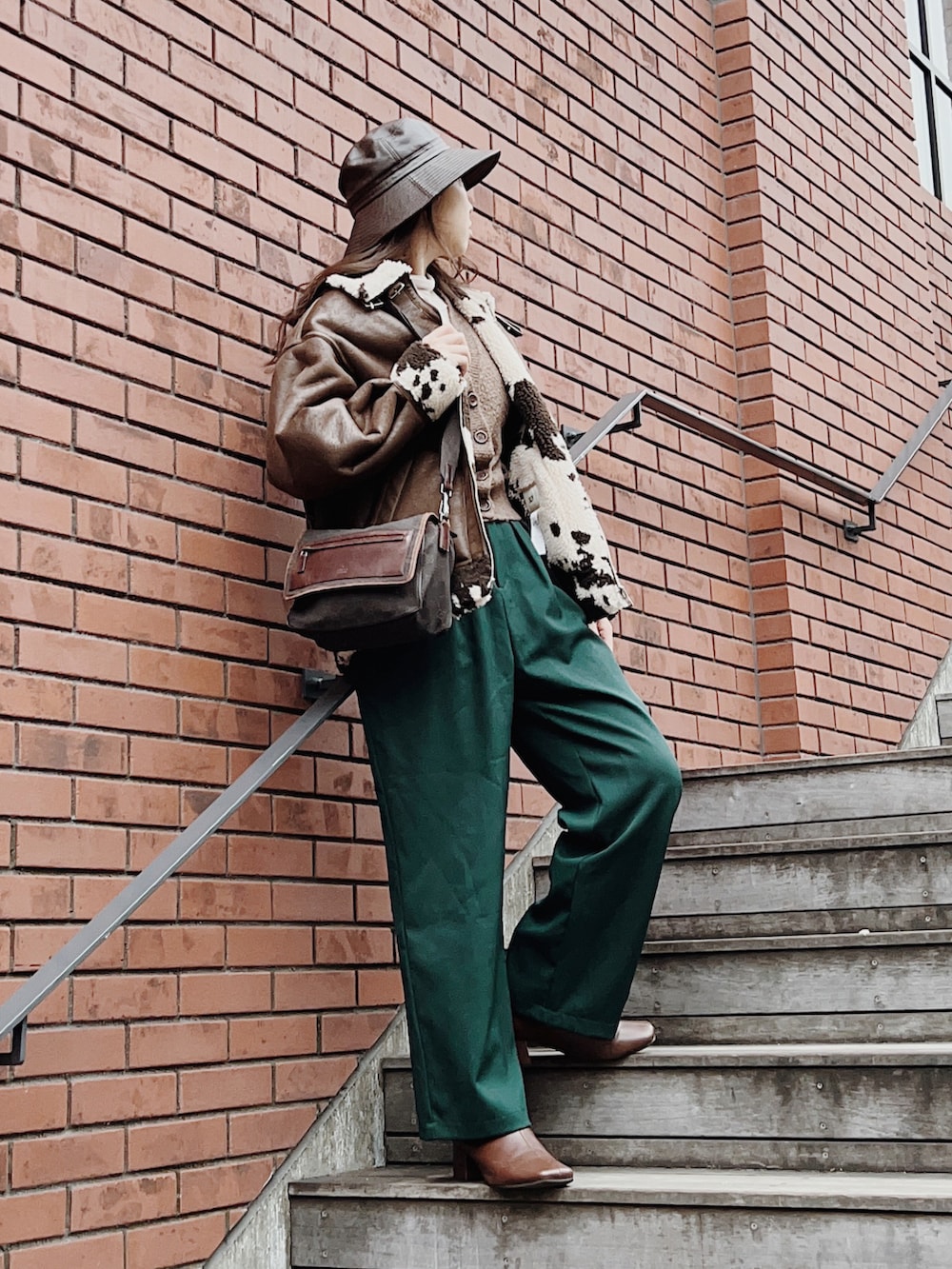 グリーン系のその他パンツ、ブラウン系のブーツ、ブラウン系のカーディガン/ボレロを着用したレディースの冬コーディネートの2枚目の写真