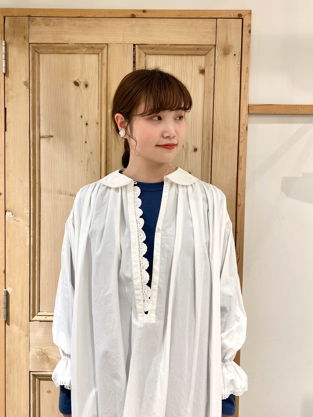 ホワイト系のチュニック、ブルー系のTシャツ/カットソー、ブラック系のその他パンツを着用したレディースの春コーディネートの2枚目の写真