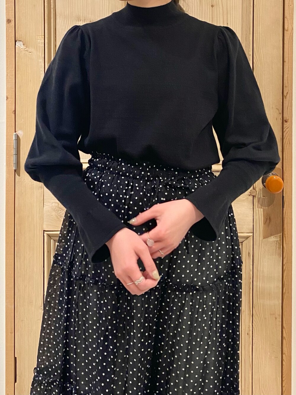 ブラック系のニット/セーター、ブラック系のスカート、ホワイト系のその他パンツを着用したレディースの冬コーディネートの2枚目の写真