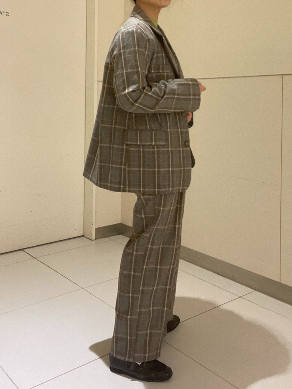 グリーン系のニット/セーター、グレー系のベスト、グレー系のテーラードジャケットを着用したレディースの秋コーディネートの2枚目の写真