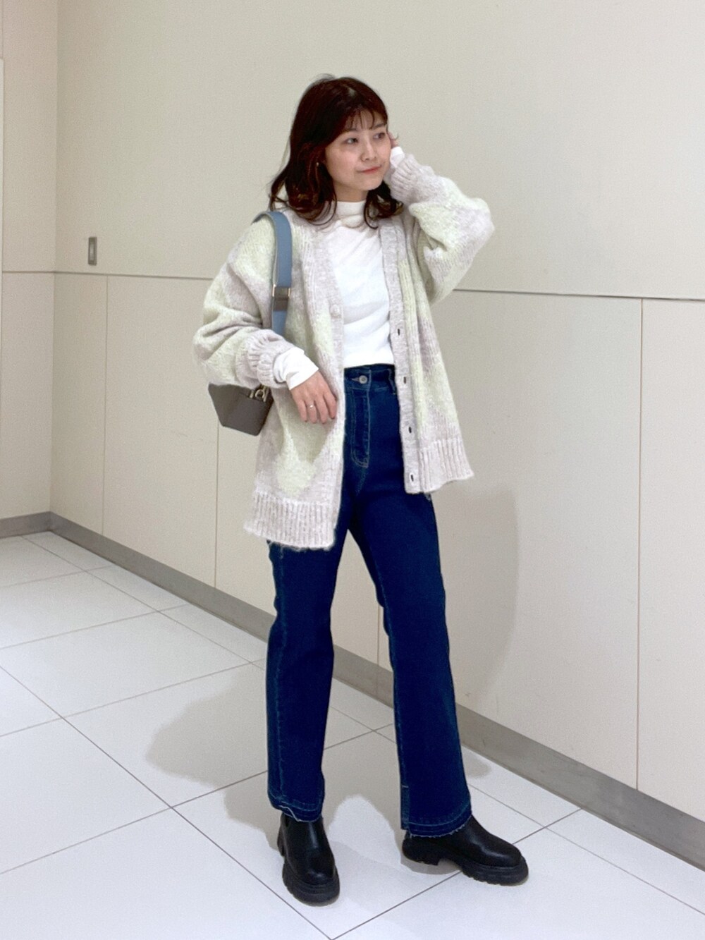 グレー系のボディバッグ/ウエストポーチ、ホワイト系のTシャツ/カットソー、グリーン系のカーディガン/ボレロを着用したレディースの秋コーディネートの2枚目の写真