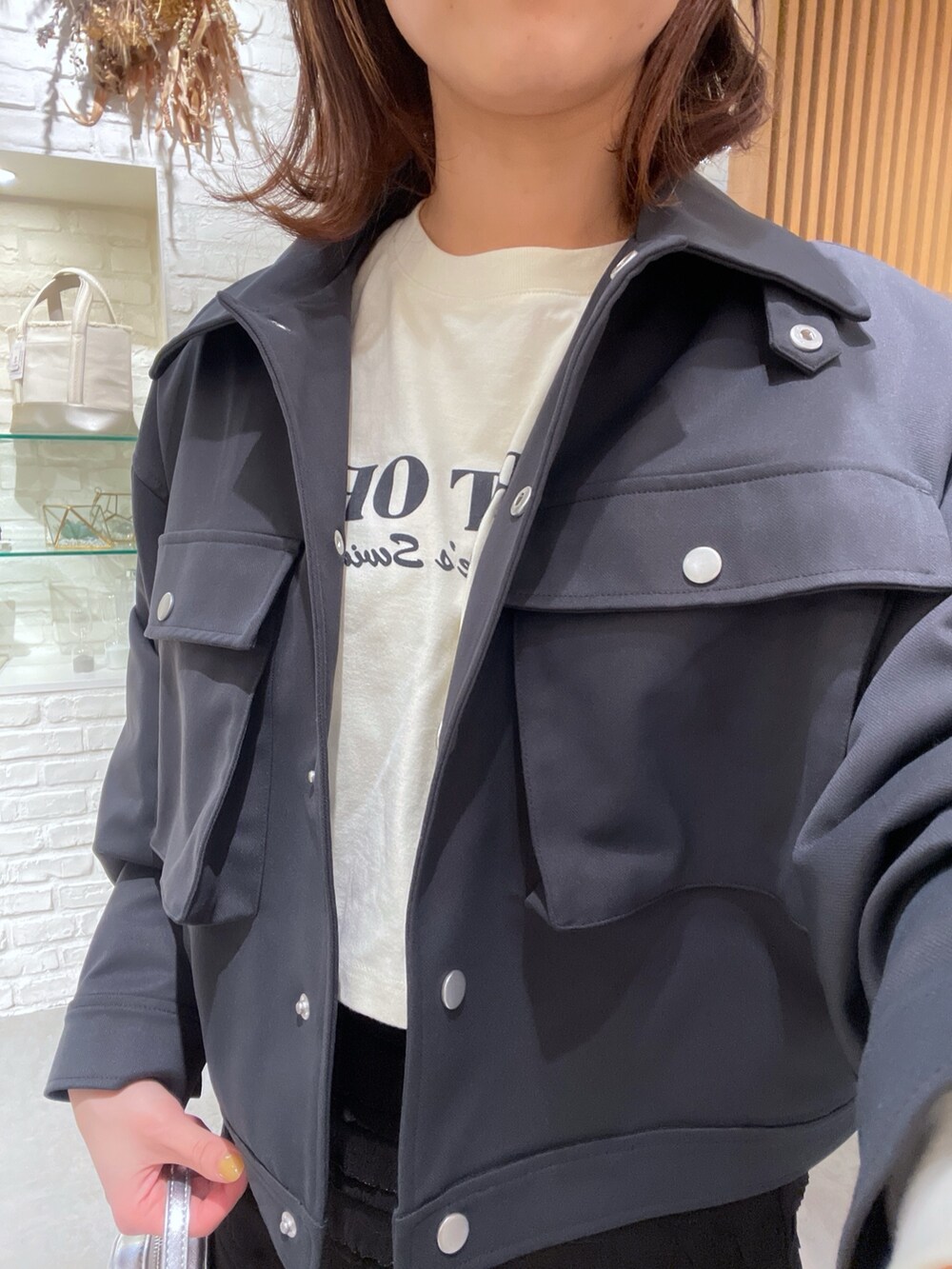 ベージュ系のTシャツ/カットソー、ブラック系のスカート、ブラック系のショルダーバッグを着用したレディースの春コーディネートの5枚目の写真