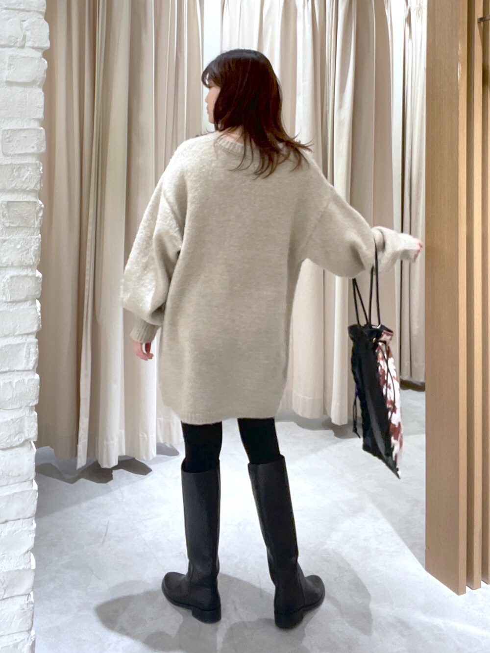 ベージュ系のワンピース、ブラック系のハンドバッグを着用したレディースの冬コーディネートの3枚目の写真