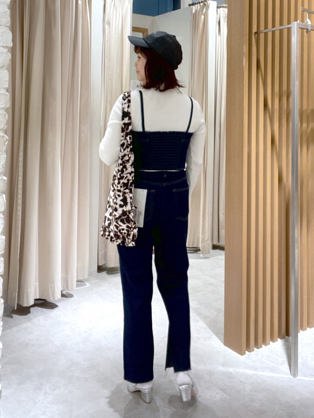 ホワイト系のニット/セーター、ブルー系のベスト、シルバー系のパンプスを着用したレディースの冬コーディネートの4枚目の写真