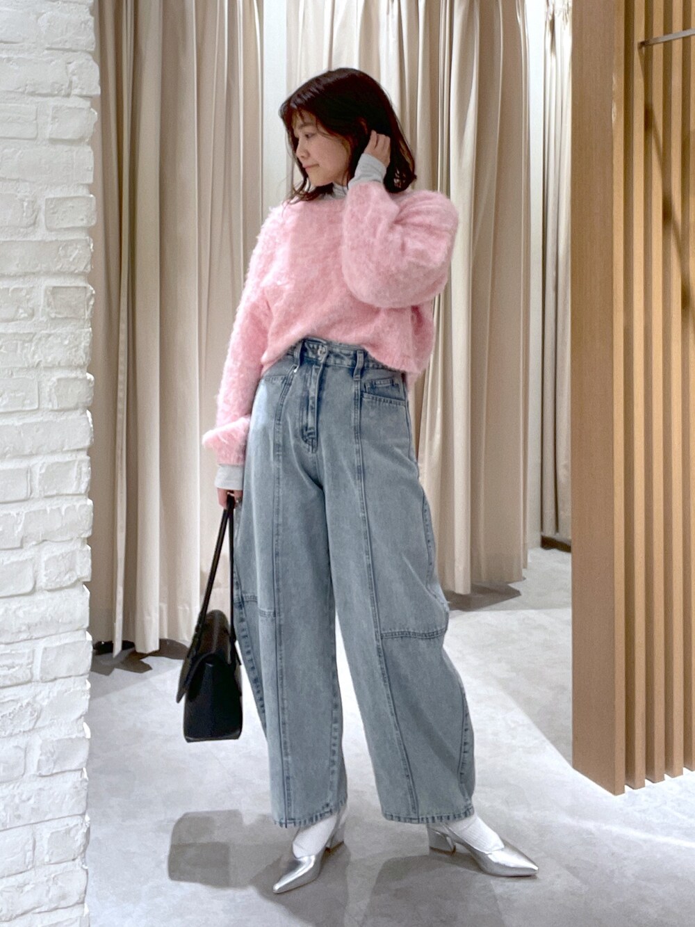 ブルー系のデニムパンツ、ブラック系のショルダーバッグ、シルバー系のパンプスを着用したレディースの冬コーディネートの2枚目の写真