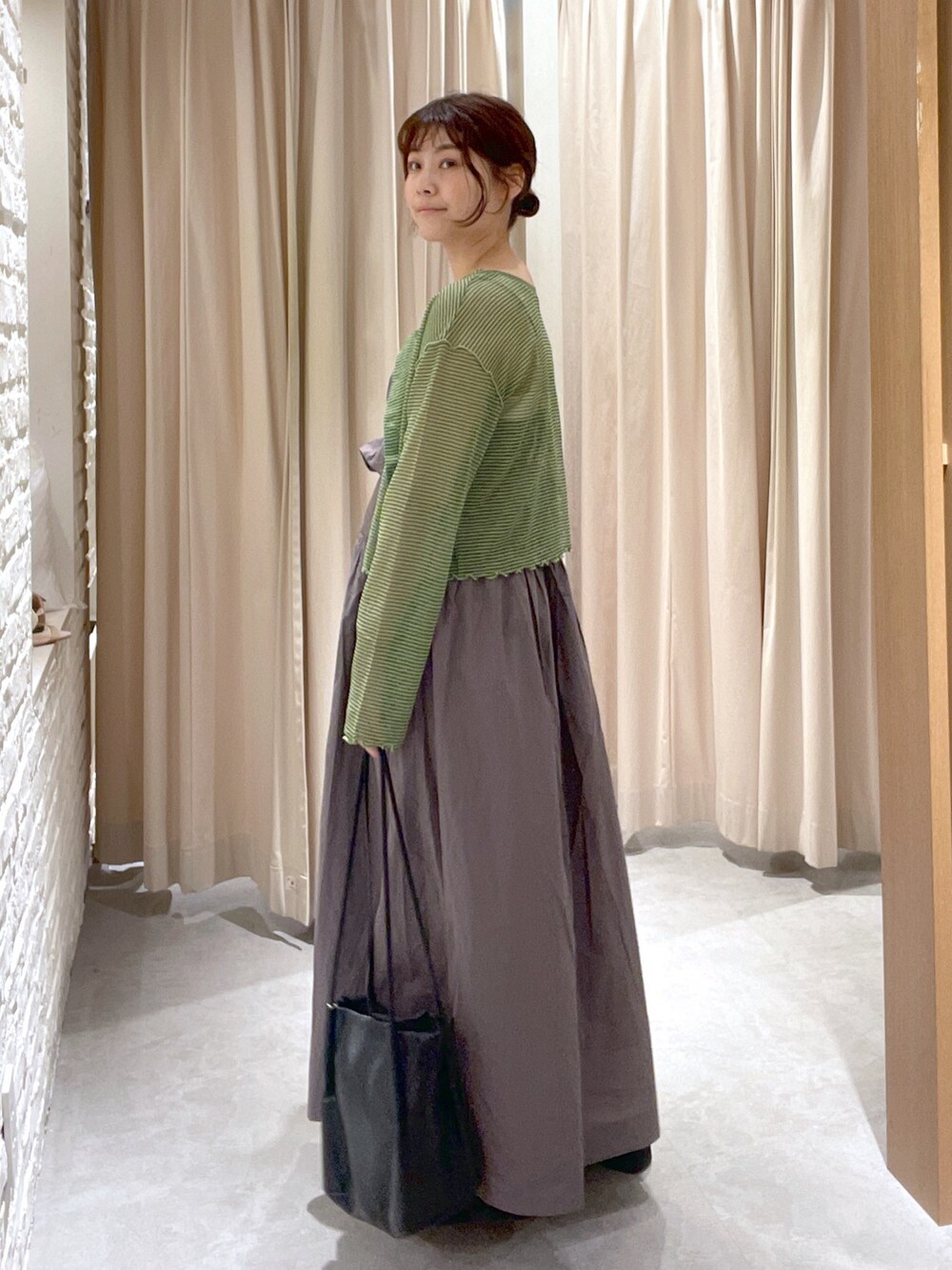 グリーン系のカーディガン/ボレロ、グレー系のワンピース、ブラック系のサンダルを着用したレディースの夏コーディネートの2枚目の写真