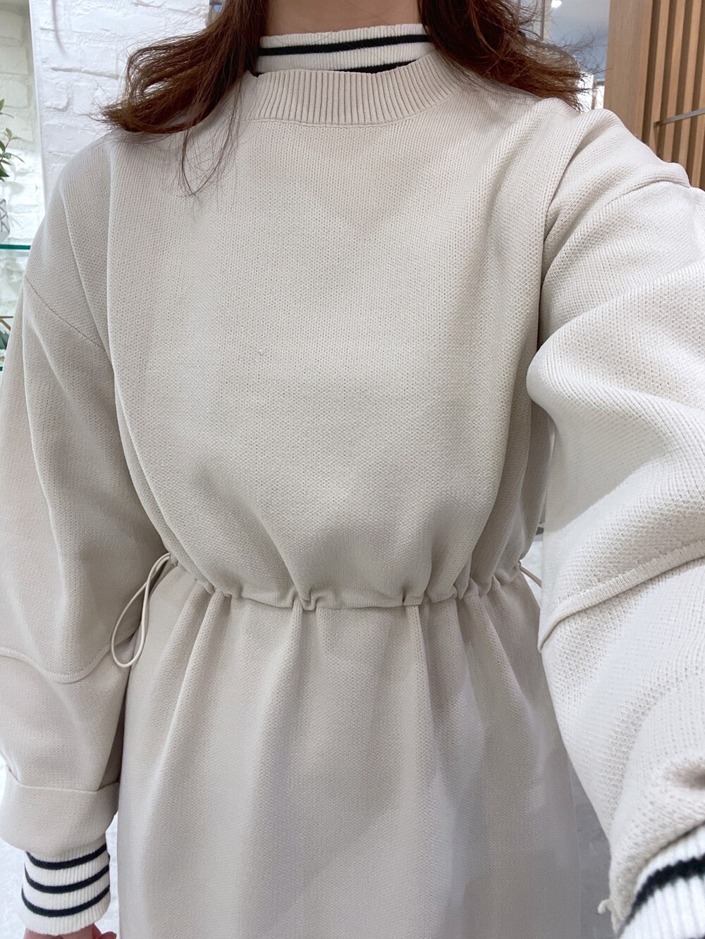 ホワイト系のワンピース、ホワイト系のニット/セーター、ベージュ系のショルダーバッグを着用したレディースの秋コーディネートの4枚目の写真