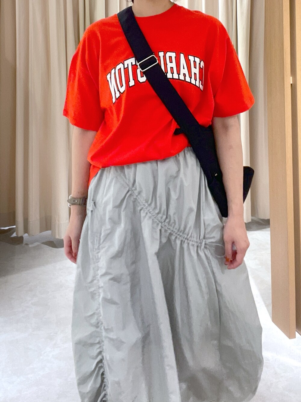 レッド系のTシャツ/カットソー、ブラック系のショルダーバッグ、グレー系のスカートを着用したレディースの夏コーディネートの4枚目の写真