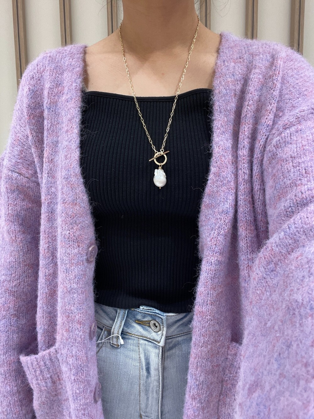 パープル系のカーディガン/ボレロ、ブラック系のTシャツ/カットソー、ブルー系のデニムパンツを着用したレディースの秋コーディネートの4枚目の写真