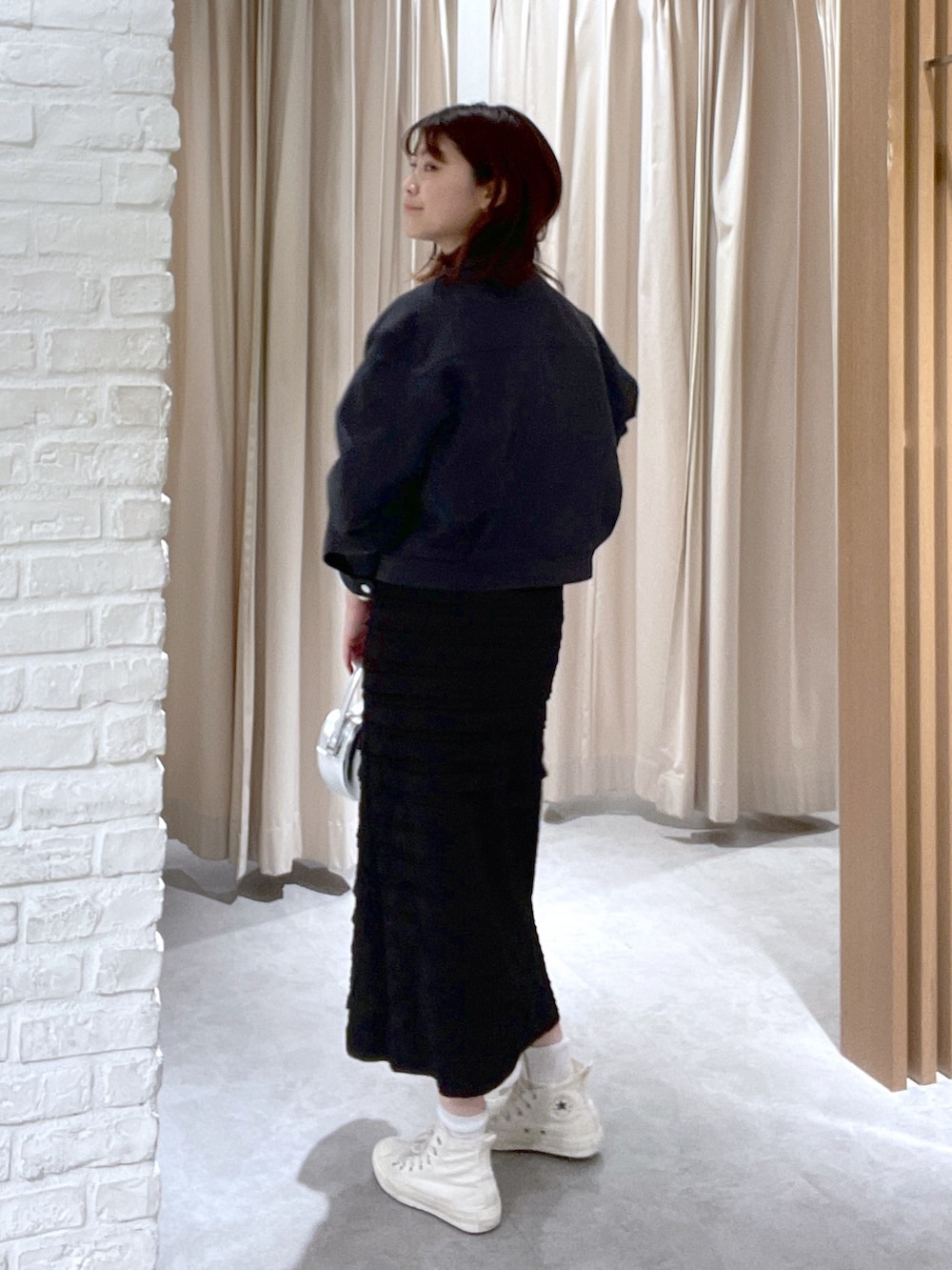 ベージュ系のTシャツ/カットソー、ブラック系のスカート、ブラック系のショルダーバッグを着用したレディースの春コーディネートの4枚目の写真