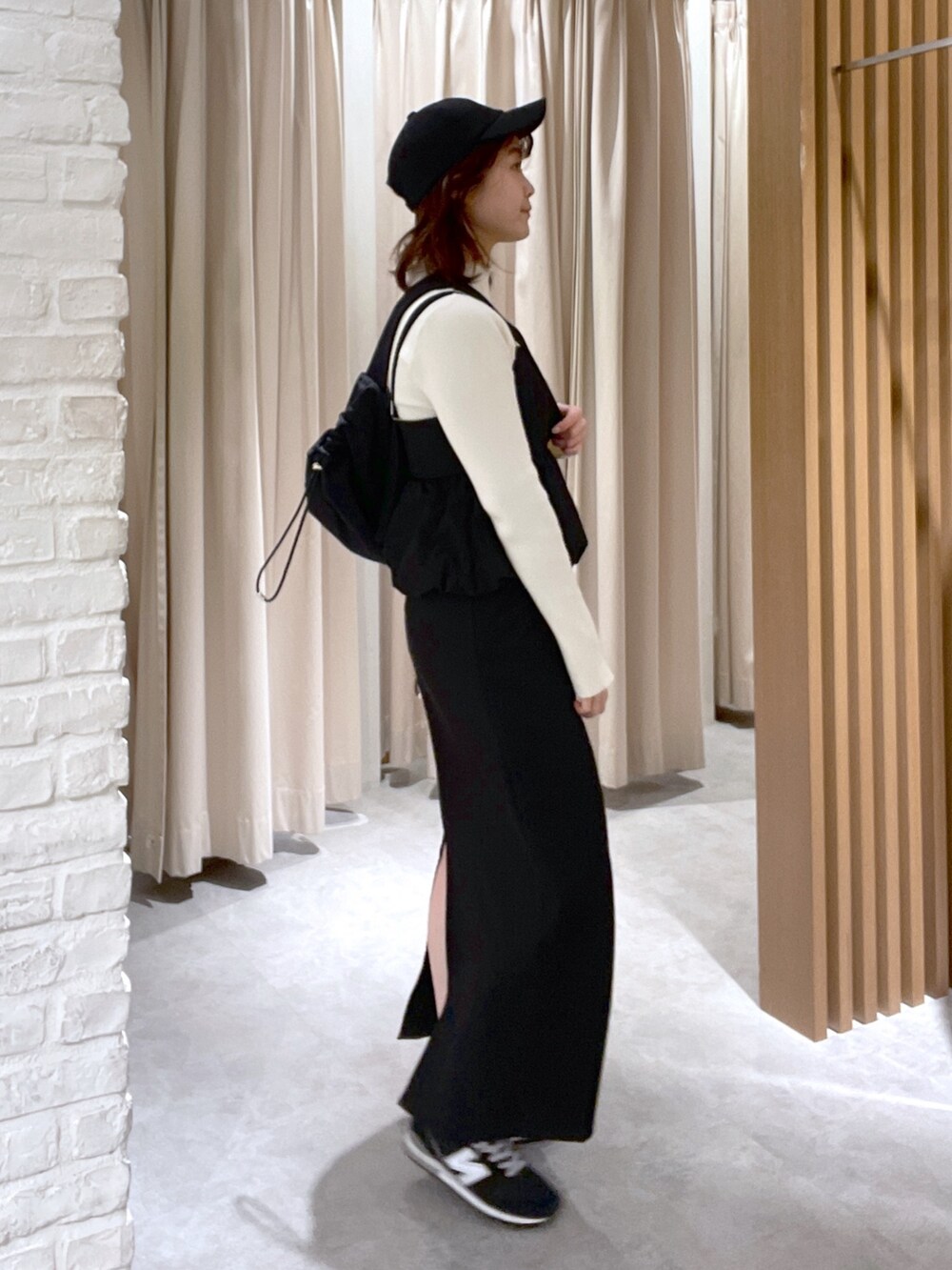 ホワイト系のニット/セーター、ブラック系のワンピース、ブラック系のショルダーバッグを着用したレディースの冬コーディネートの3枚目の写真