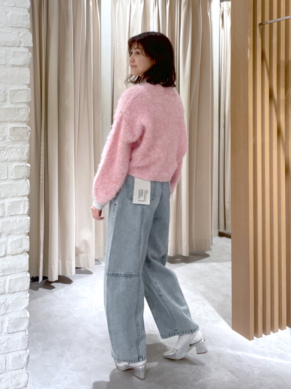 ブルー系のデニムパンツ、ブラック系のショルダーバッグ、シルバー系のパンプスを着用したレディースの冬コーディネートの4枚目の写真