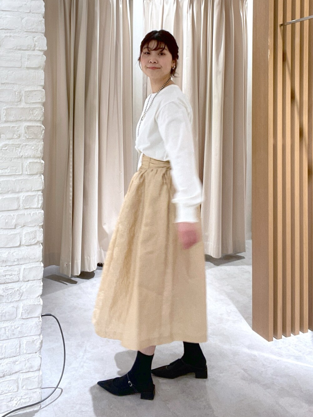 ホワイト系のTシャツ/カットソー、ブラック系のハンドバッグ、ブラック系のパンプスを着用したレディースの春コーディネートの3枚目の写真