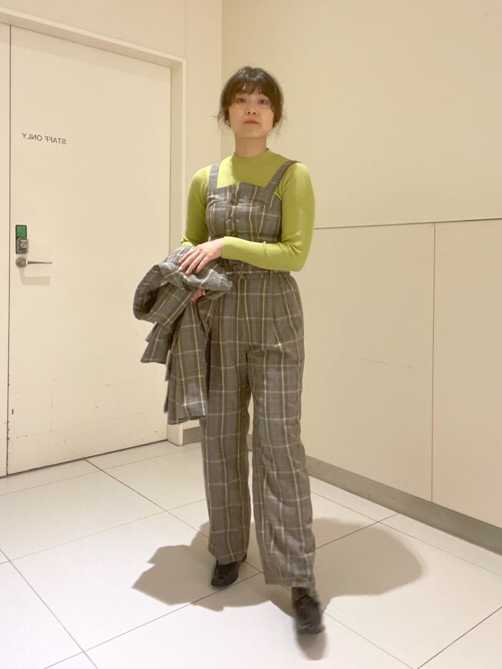 グリーン系のニット/セーター、グレー系のベスト、グレー系のテーラードジャケットを着用したレディースの秋コーディネートの4枚目の写真