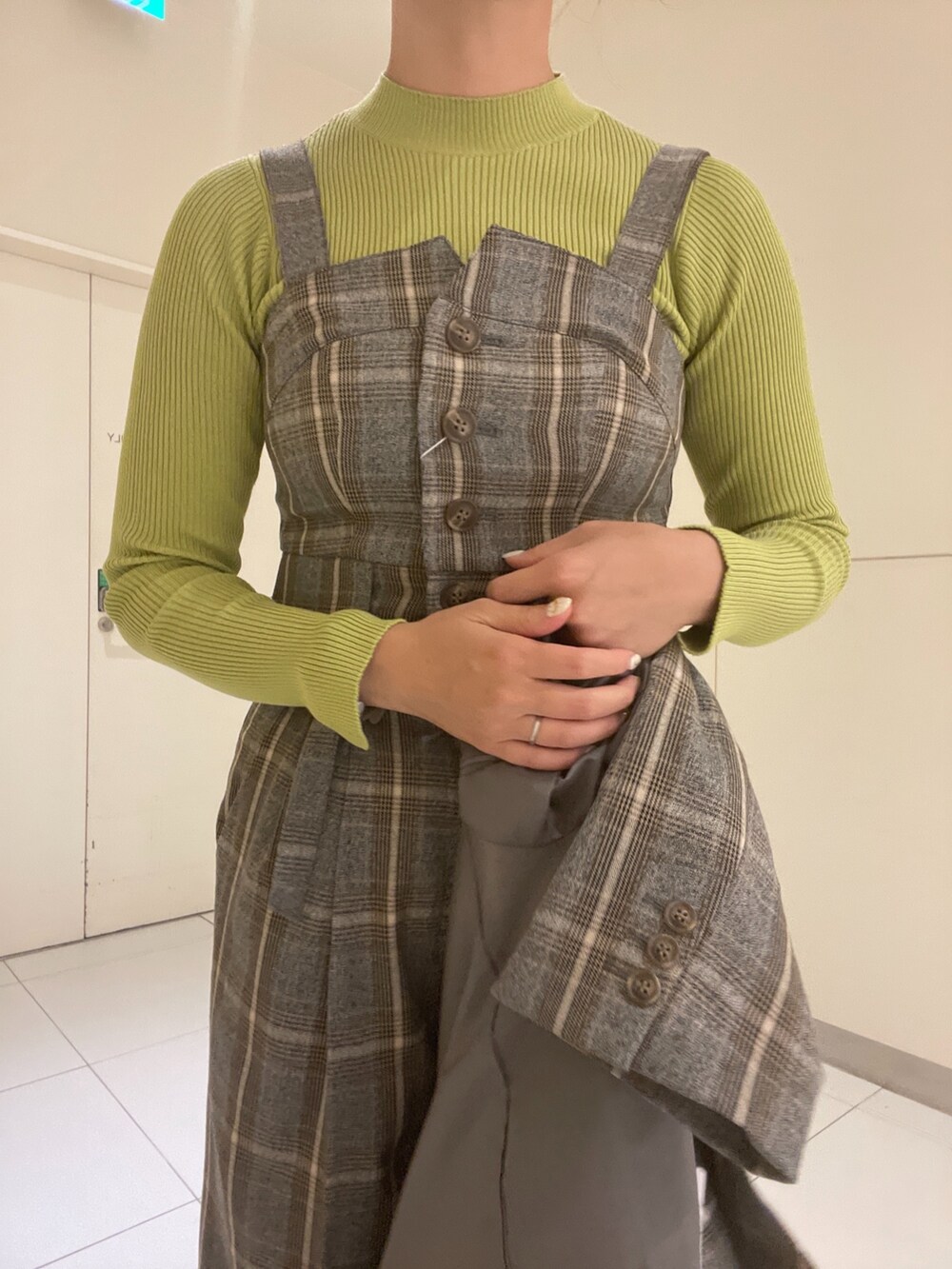 グリーン系のニット/セーター、グレー系のベスト、グレー系のテーラードジャケットを着用したレディースの秋コーディネートの6枚目の写真