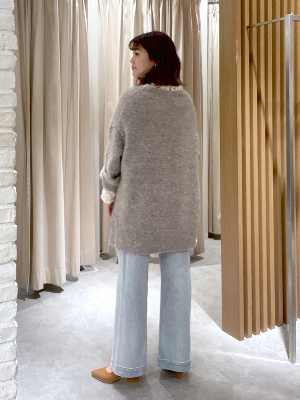 ホワイト系のシャツ/ブラウス、ベージュ系のカーディガン/ボレロ、ブルー系のデニムパンツを着用したレディースの冬コーディネートの3枚目の写真