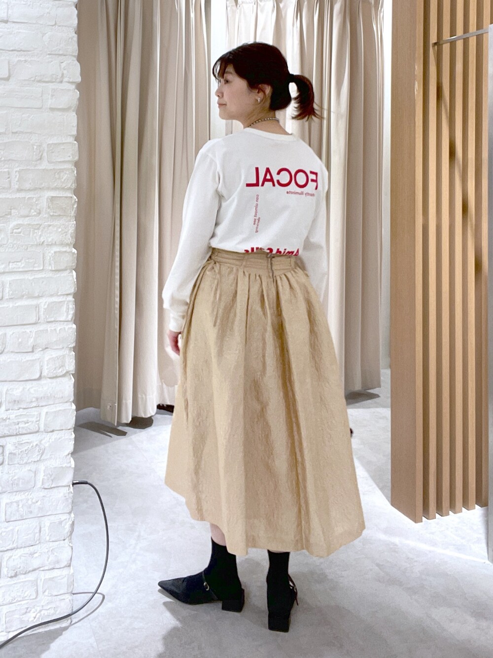 ホワイト系のTシャツ/カットソー、ブラック系のハンドバッグ、ブラック系のパンプスを着用したレディースの春コーディネートの4枚目の写真