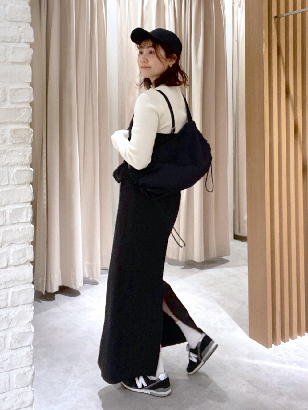 ホワイト系のニット/セーター、ブラック系のワンピース、ブラック系のショルダーバッグを着用したレディースの冬コーディネートの4枚目の写真