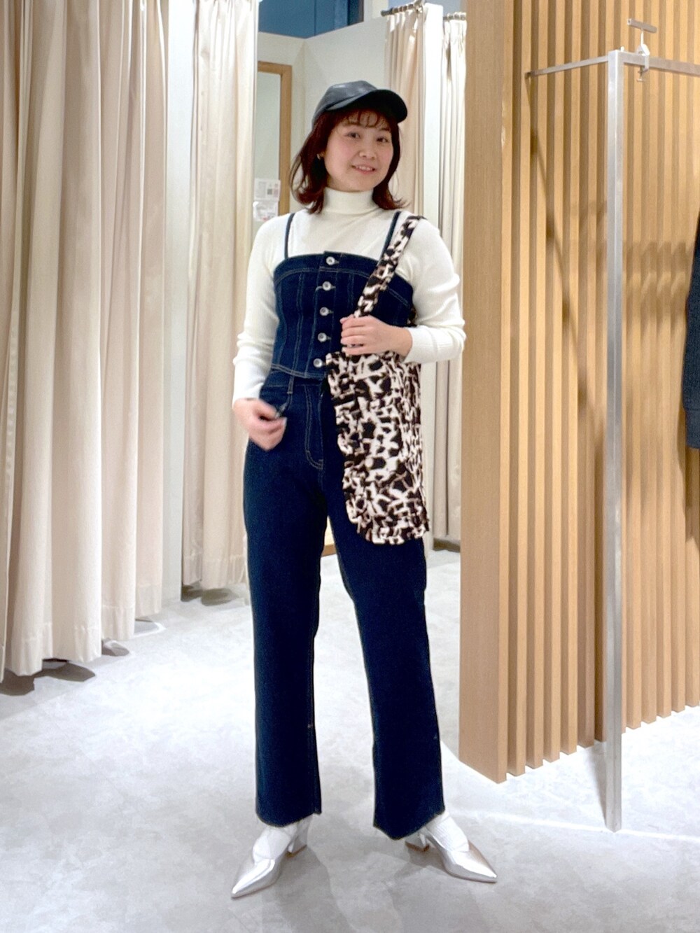 ホワイト系のニット/セーター、ブルー系のベスト、シルバー系のパンプスを着用したレディースの冬コーディネートの2枚目の写真