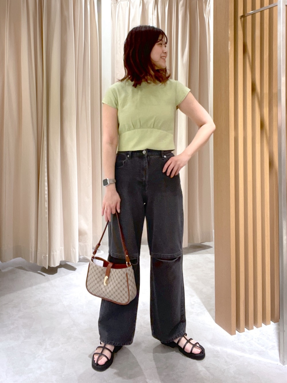 グリーン系のシャツ/ブラウス、ブラック系のデニムパンツ、ベージュ系のショルダーバッグを着用したレディースの春コーディネートの5枚目の写真