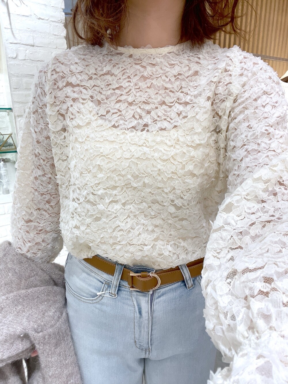 ホワイト系のシャツ/ブラウス、ベージュ系のカーディガン/ボレロ、ブルー系のデニムパンツを着用したレディースの冬コーディネートの4枚目の写真