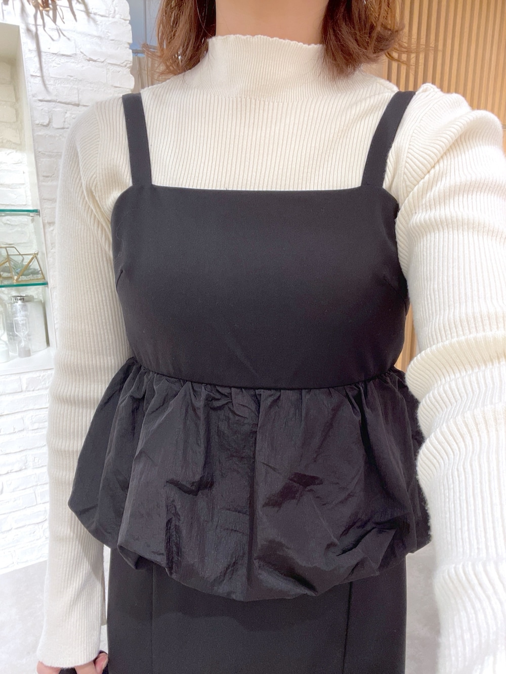 ホワイト系のニット/セーター、ブラック系のワンピース、ブラック系のショルダーバッグを着用したレディースの冬コーディネートの6枚目の写真