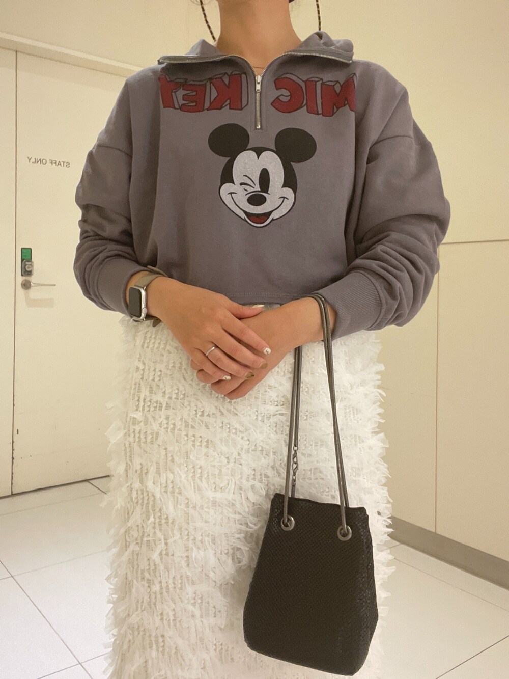 ブラック系のスウェット、ブラック系のショルダーバッグ、ホワイト系のスカートを着用したレディースの秋コーディネートの4枚目の写真