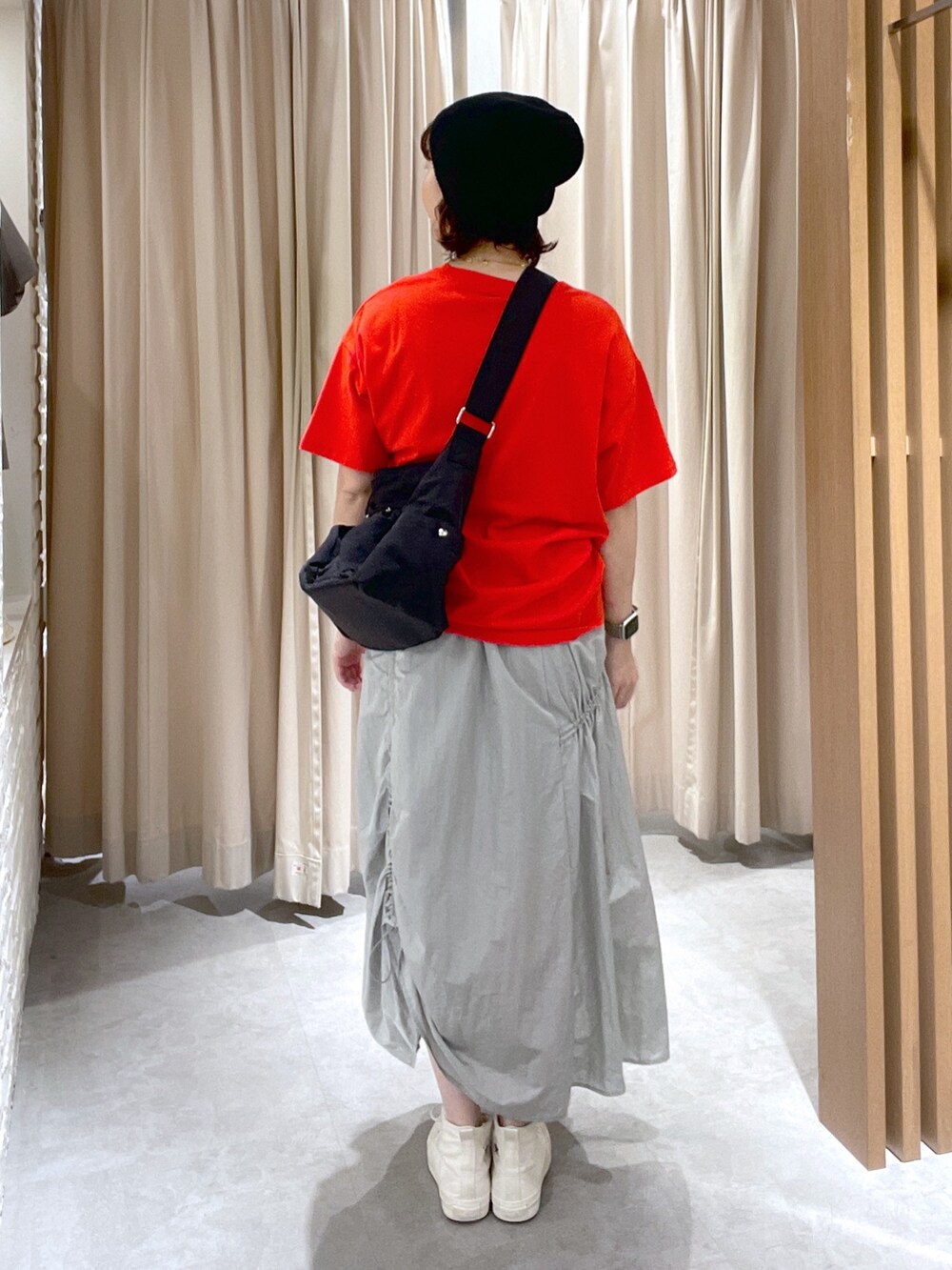 レッド系のTシャツ/カットソー、ブラック系のショルダーバッグ、グレー系のスカートを着用したレディースの夏コーディネートの3枚目の写真