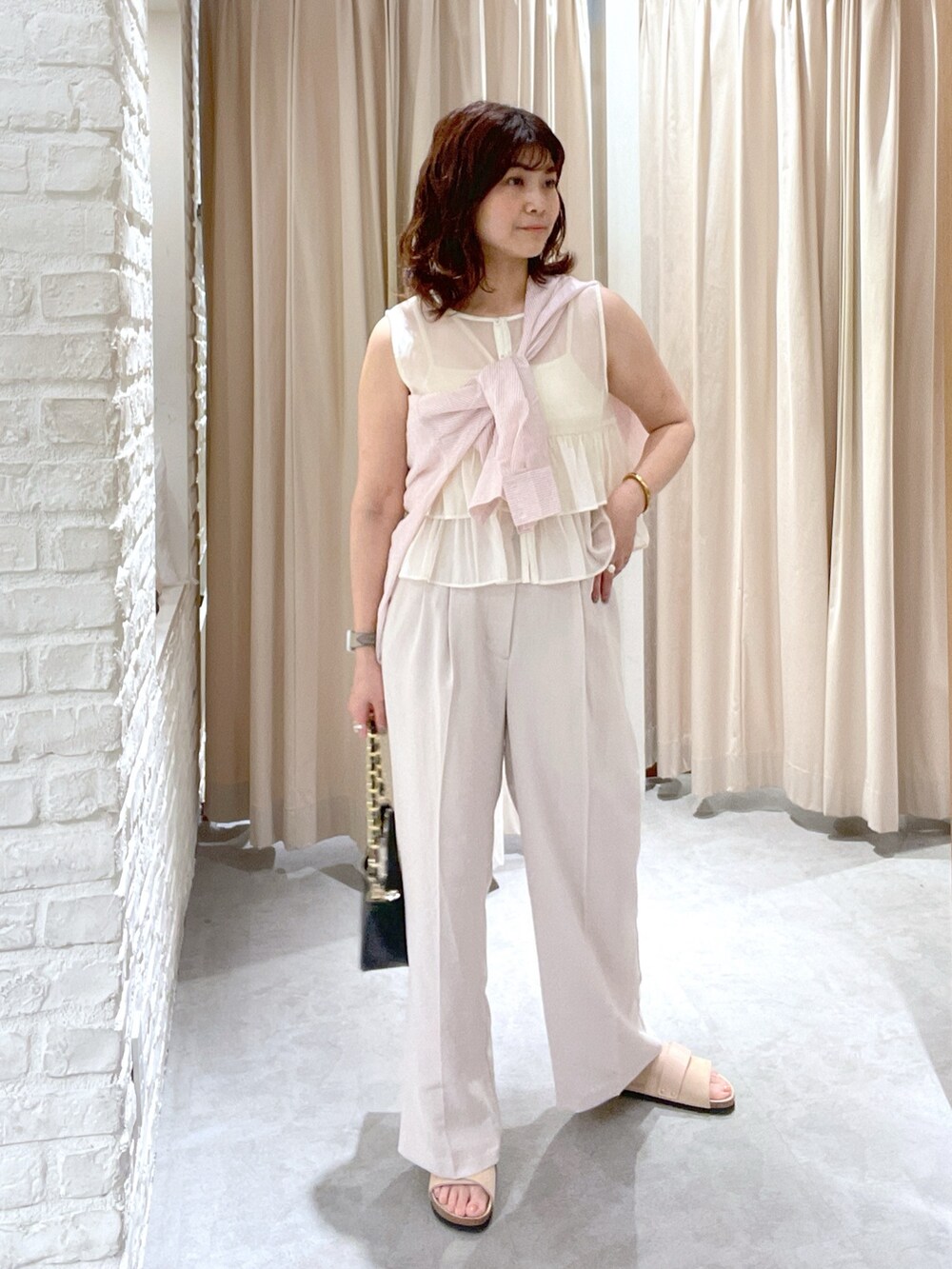 ピンク系のシャツ/ブラウス、ホワイト系のシャツ/ブラウス、ホワイト系のスラックスを着用したレディースの夏コーディネートの2枚目の写真