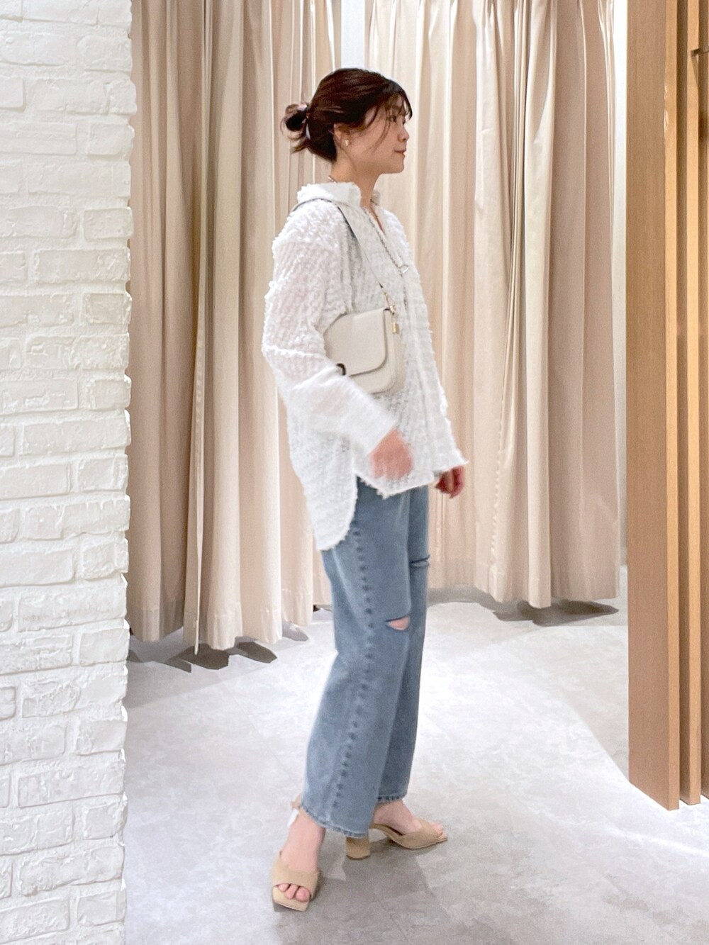 ホワイト系のシャツ/ブラウス、ブルー系のデニムパンツ、ホワイト系のショルダーバッグを着用したレディースの春コーディネートの2枚目の写真