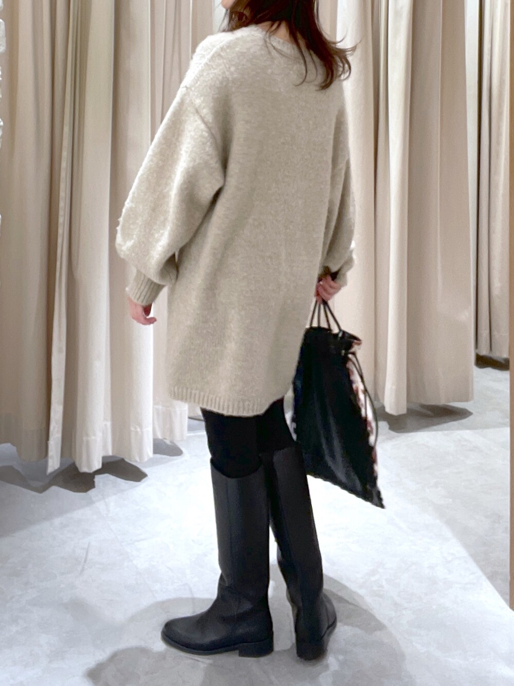 ベージュ系のワンピース、ブラック系のハンドバッグを着用したレディースの冬コーディネートの5枚目の写真