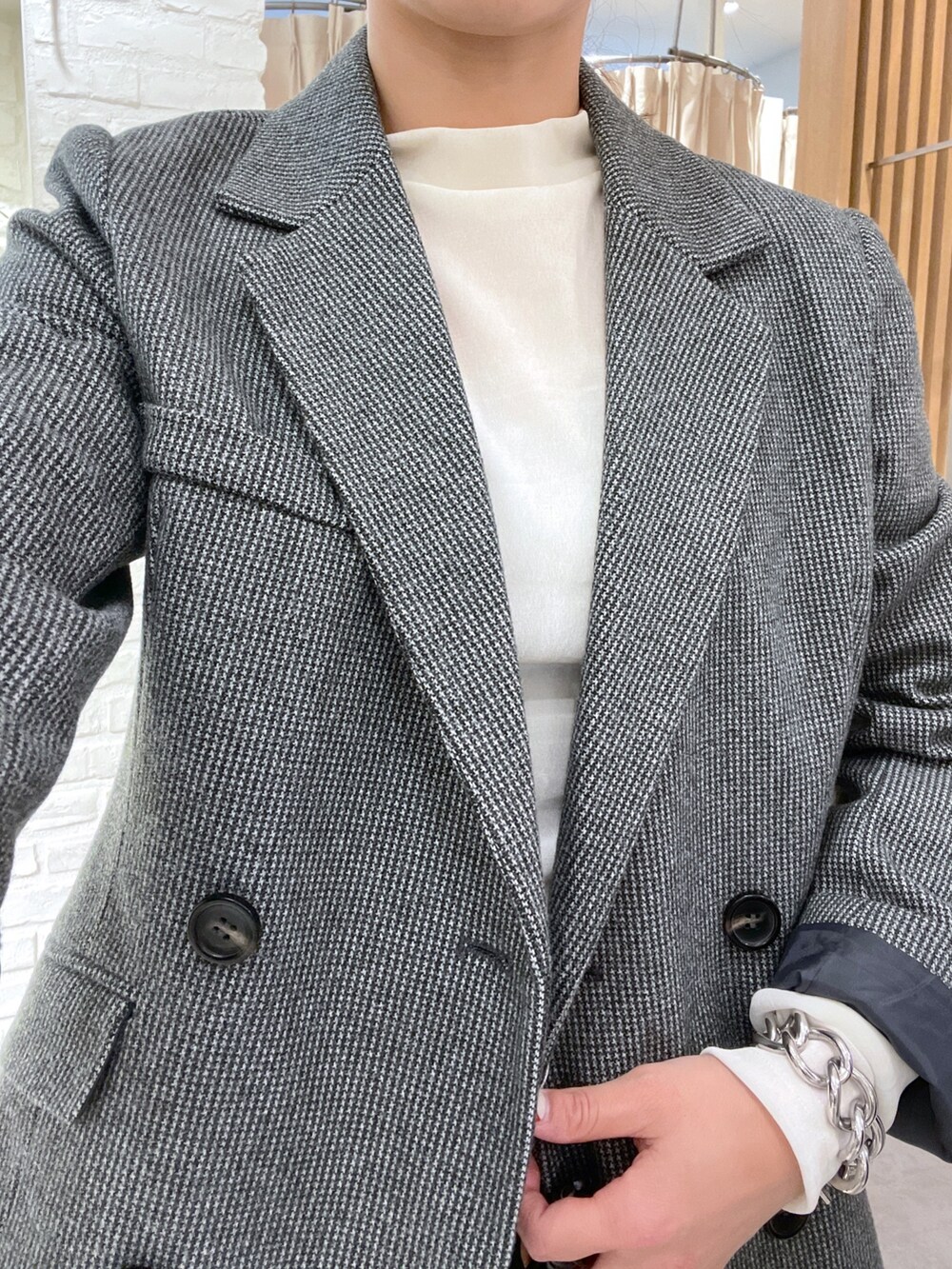 ホワイト系のTシャツ/カットソー、ブラック系のテーラードジャケット、ブラック系のスカートを着用したレディースの秋コーディネートの6枚目の写真